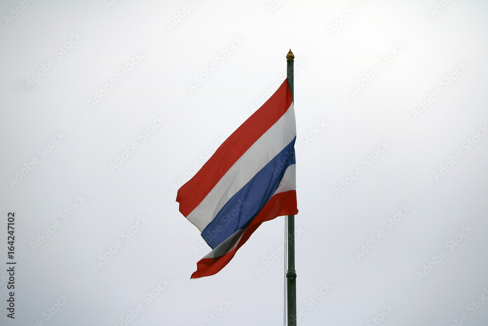 Thai National flag on the sky background. The flag of Thailand is striped in 3 colors: red, white and blue.
