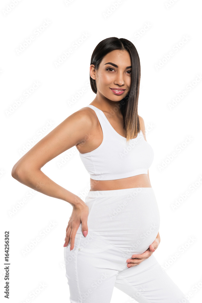 smiling pregnant asian woman in white clothes touching her belly, isolated on white smiling pregnant asian woman in white clothes touching her belly, isolated on white