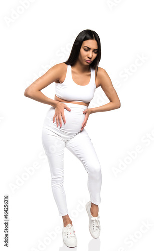 worried pregnant asian woman touching her belly, isolated on white