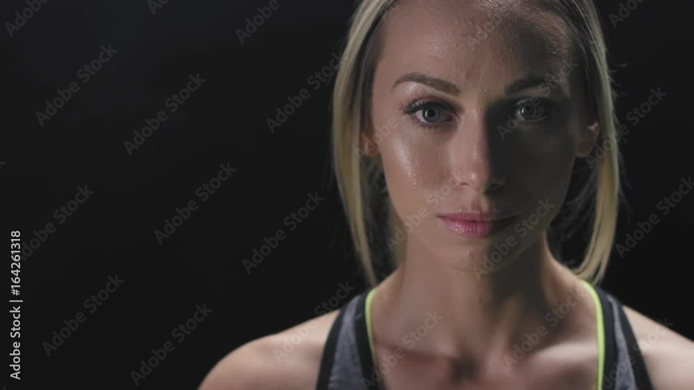 Portrait shot of an athletic caucasian woman breathing deeply on a foggy dark background Portrait shot of an athletic caucasian woman breathing deeply on a foggy dark background