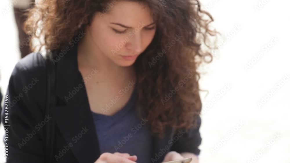 Beautiful young woman with a smartphone in the hands of the city
