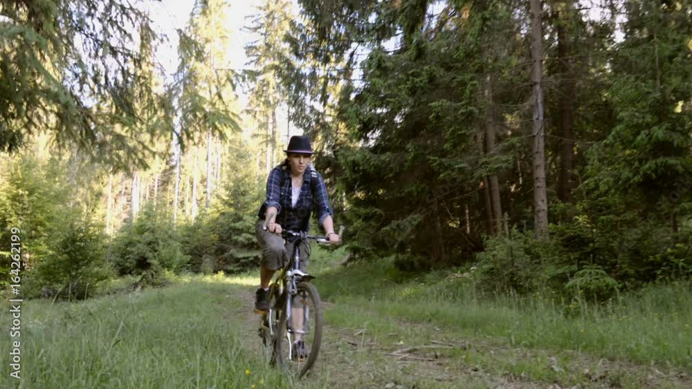Young woman rides a bicycle in the mountains in the forest. Mountain biking. Young woman rides a bicycle in the mountains in the forest. Mountain biking.