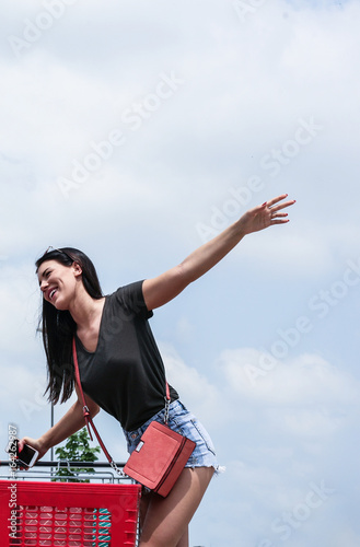 Young woman having fun on a shopping cart in the city.