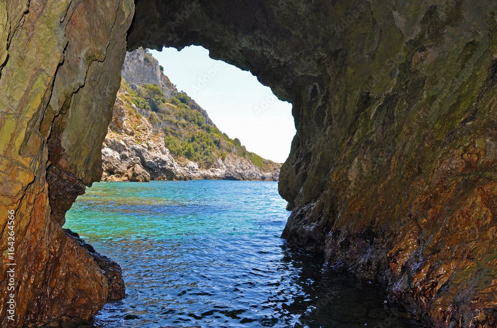 Green grotto with colourful walls and emerald water