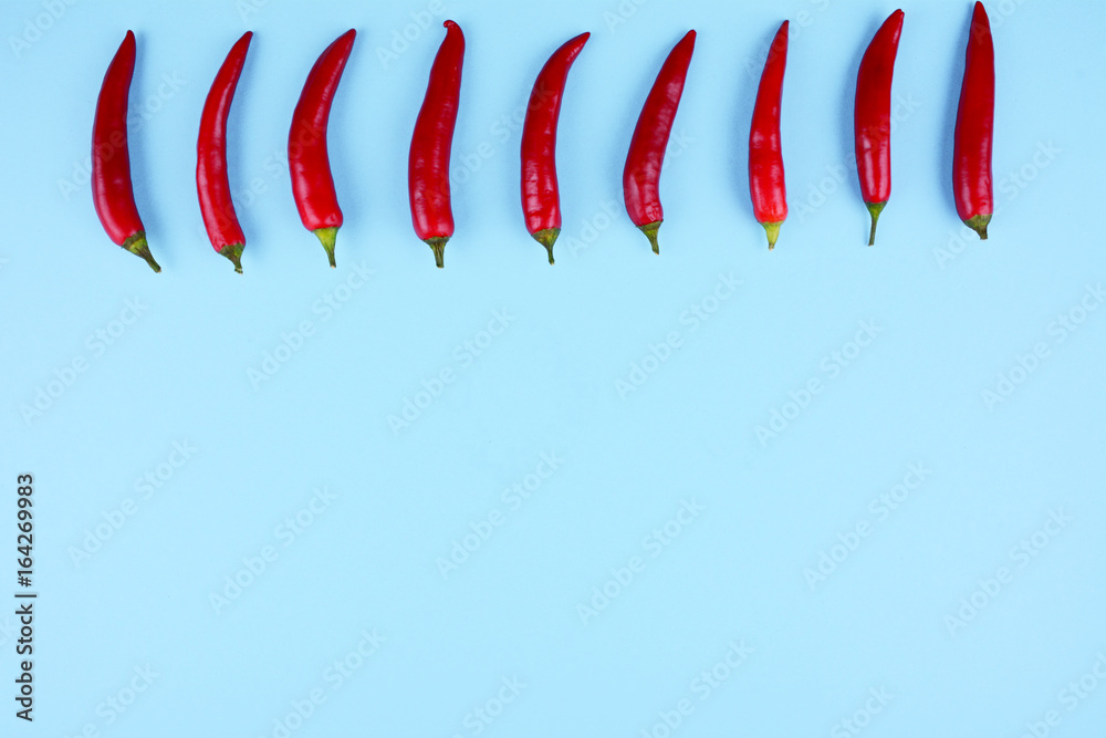 Obraz premium Red chilli papper on blue background.
