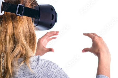 Fotografie A woman in virtual reality glasses holds an imaginary object