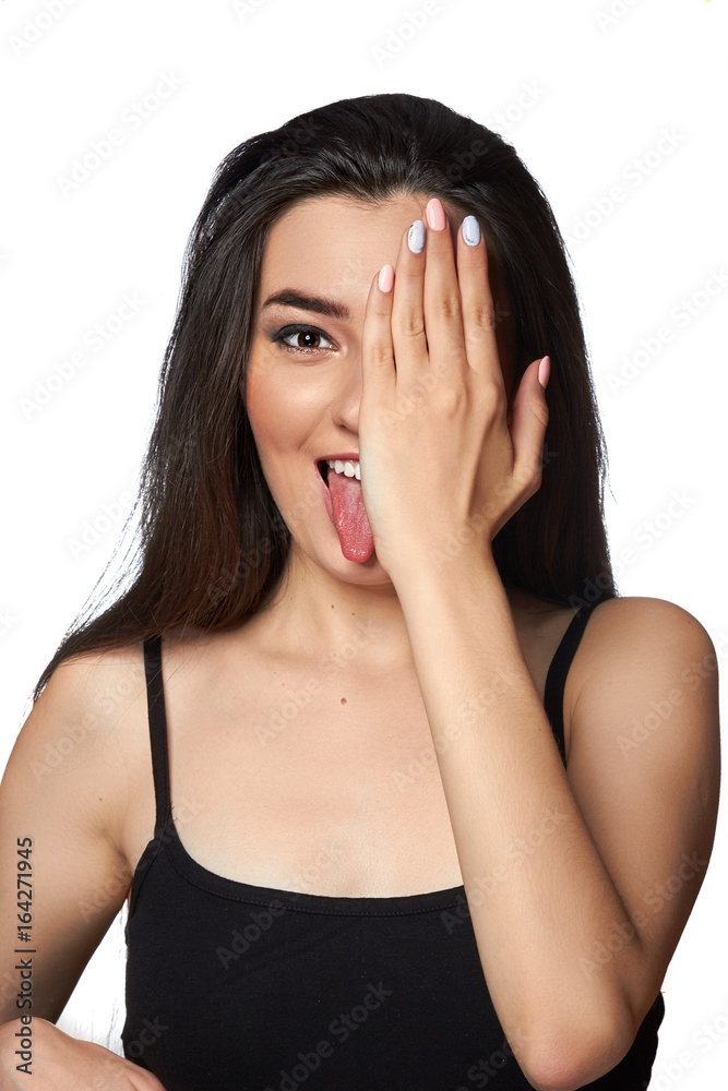 Emotional girl. Beautiful model shows tongue and close one eyes with hand.Positive girl. Emotions on face. Emotional girl. Beautiful model shows tongue and close one eyes with hand.Positive girl. Emotions on face.
