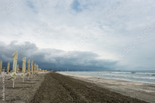 Landscape with sea view, waves and sea shells, clouds, photographed in Mamaia, Romania, in cloudy spring day photo