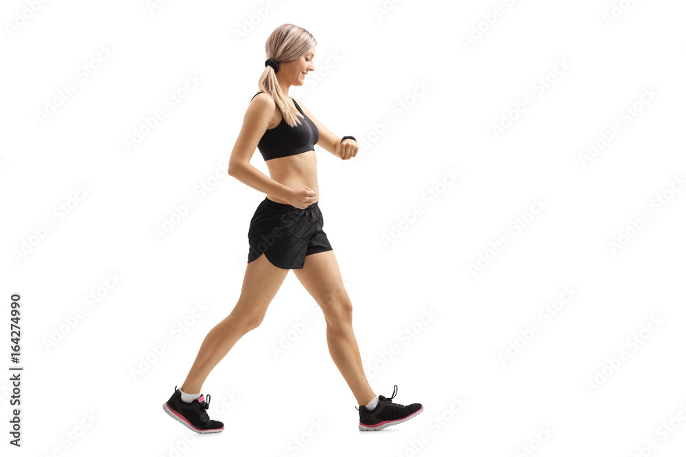 Woman walking and checking her sports watch Woman walking and checking her sports watch