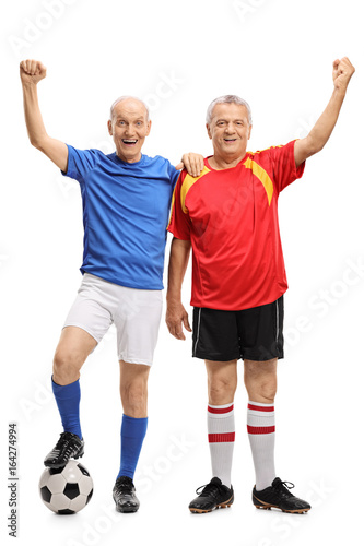 Full length portrait of two elderly soccer players gesturing happiness isolated on white background
