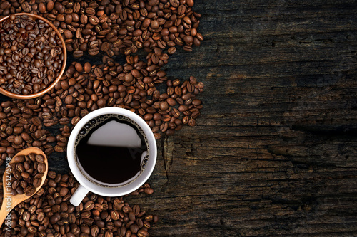 Coffee background, top view with copy space. White cup of coffee and, ground coffee, coffee beans on dark wooden background