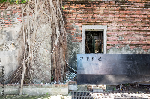 Tainan, Taiwan - July 12, 2017 Anping Tree House. This old warehouse is covered by branched of ancient Banyan Tree branch which is respected as sacred tree. It was originally warehouse of Tait & Co. photo