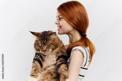 Beautiful young woman on white isolated background holds a cat