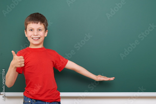 Schoolboy play near a blackboard, empty space, education concept © soleg