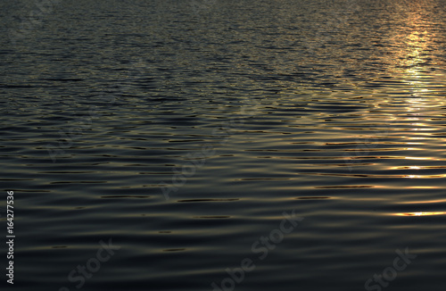 Solar path on the water, ripples on the water surface, light waves