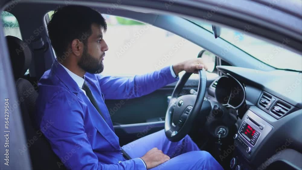 Handsome young muslim man driving the car and looking at the road. Modern muslim people. Handsome young muslim man driving the car and looking at the road. Modern muslim people.
