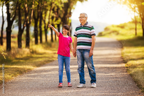 фотографія Happy grandfather and granddaughter spending time together in nature