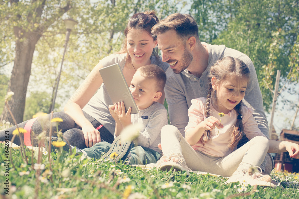 Fototapeta premium Family using tablet outdoors.