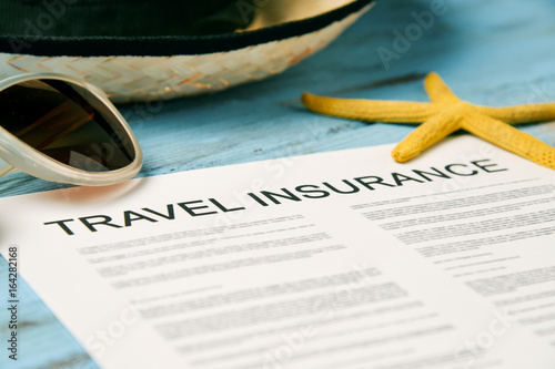 sunglasses, straw hat and travel insurance policy