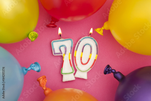 Happy Birthday number 70 celebration candle with colorful balloons