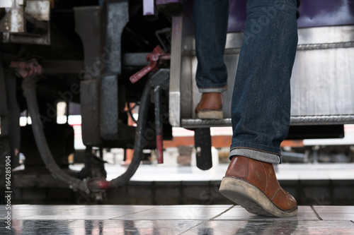 young man  tourist or traveler stepping up to the train on railway at train station. Travel  journey  trip concept