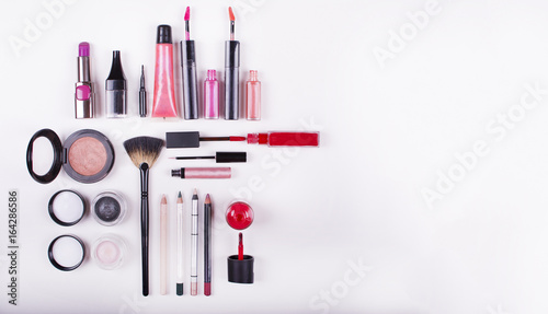 Colorful frame with various makeup products on a white background. Close up look at the mascara brushes and nail polish over a white background.