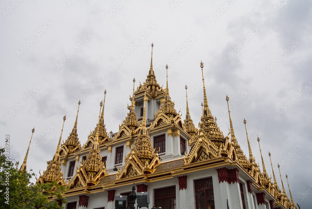 Fototapeta premium Loha Prasat Wat Ratchanatdaram in Bangkok Thailand which means iron castle or monastery is composes of five towers, of which the outer, middle and the center tower contain large black iron spires. 