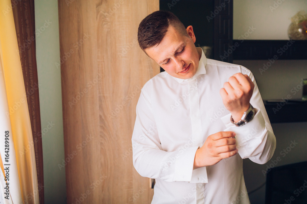 stylish groom dressing up, getting ready in morning for wedding ceremony, putting on cuff links stylish groom dressing up, getting ready in morning for wedding ceremony, putting on cuff links