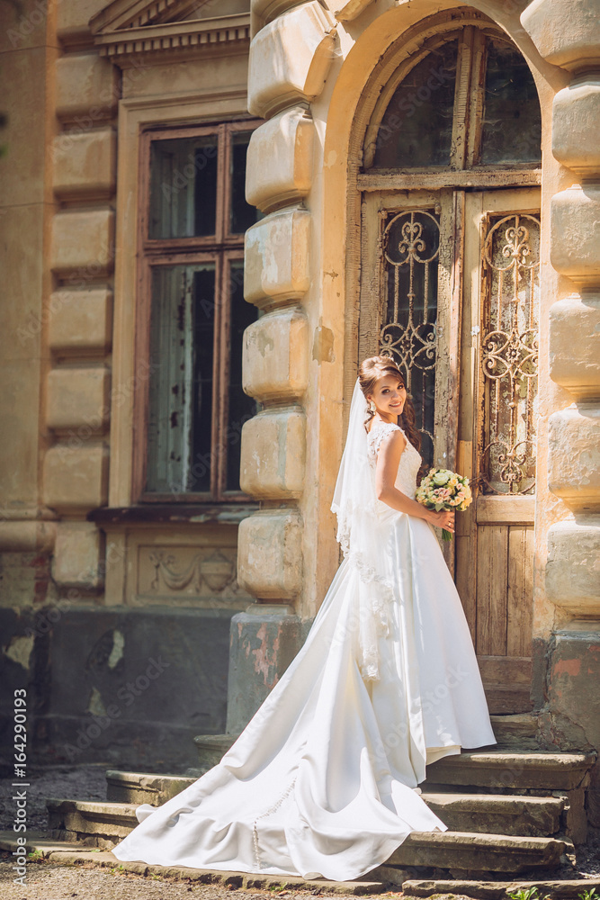 Beautiful bride near old big wooden doors