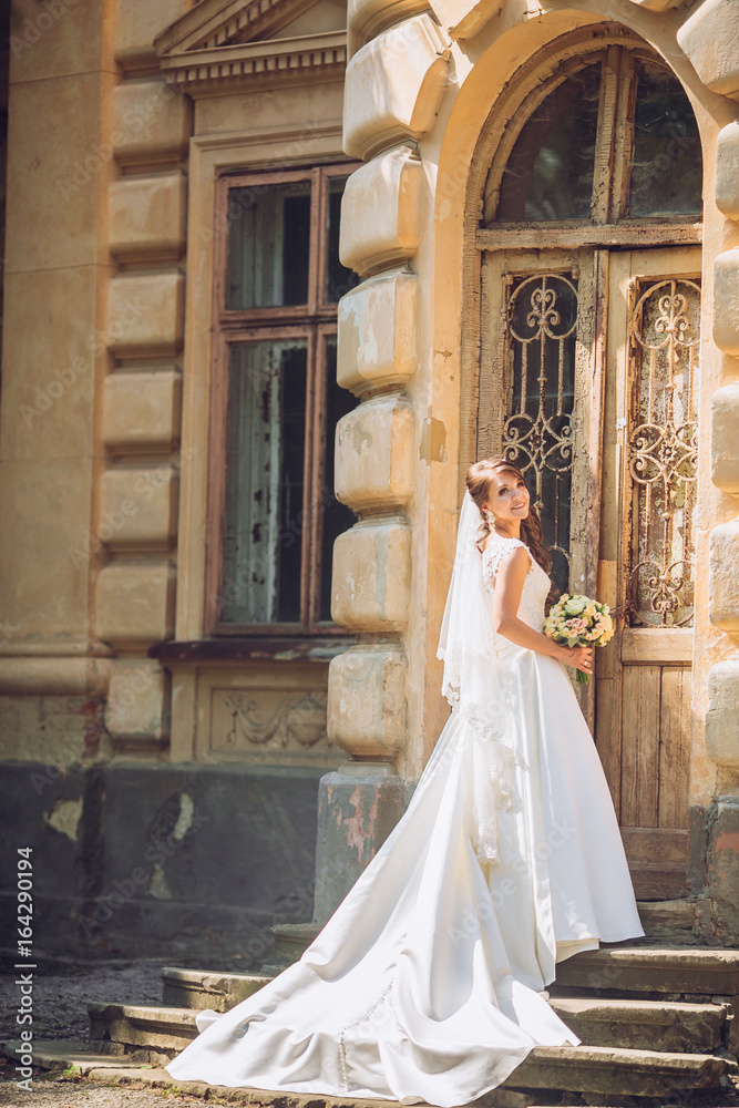Fototapeta premium Beautiful bride near old big wooden doors