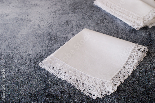   Accessories. Female white handkerchiefs with lace trim on a dark background.