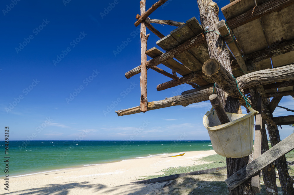 tropical sea view under wooden hut at sunny day. sandy beach and blue sky background