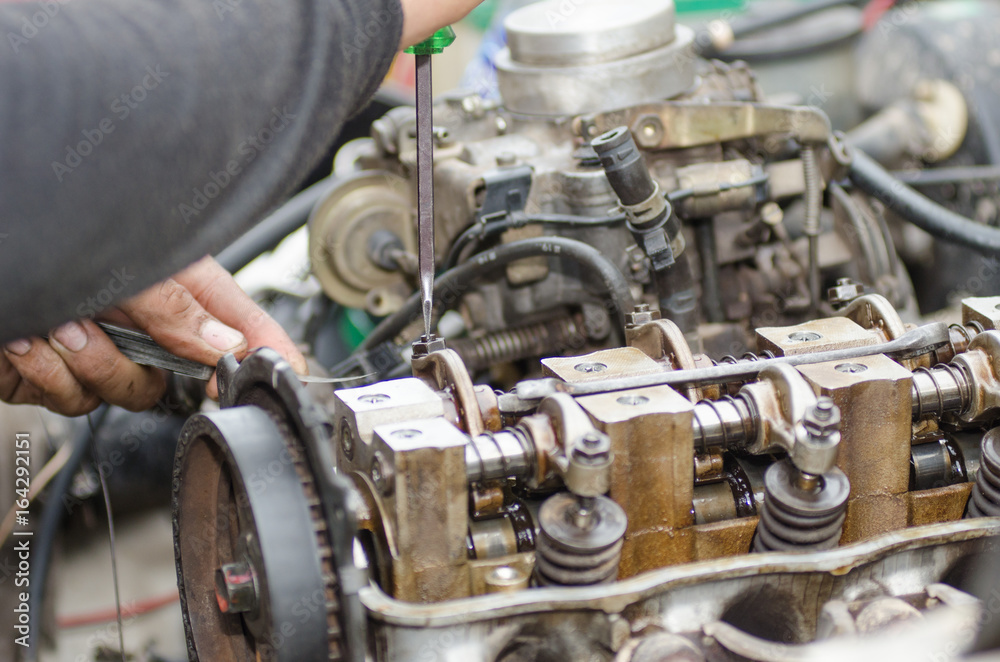 .Machinists are tuning the valve repair machine. .Machinists are tuning the valve repair machine.