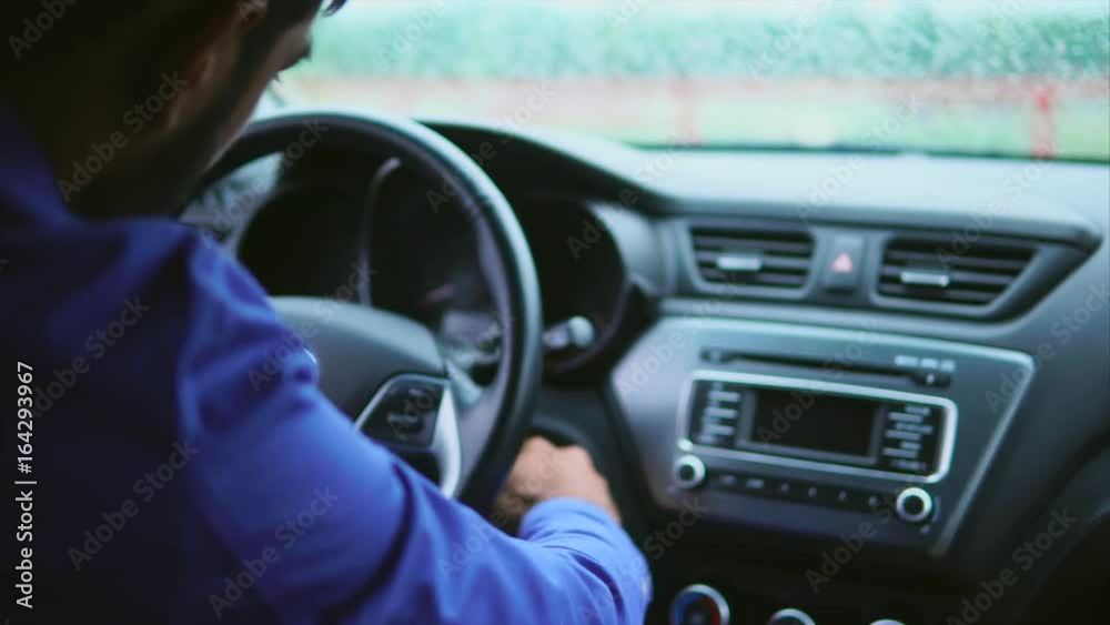 Young muslim businessman in the car. He starting the engine and ready for driving. View inside the car. Selective focus