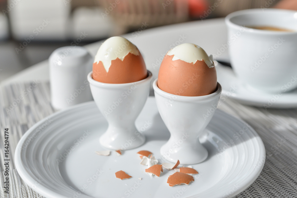 Boiled eggs in egg cup on a white plate Boiled eggs in egg cup on a white plate