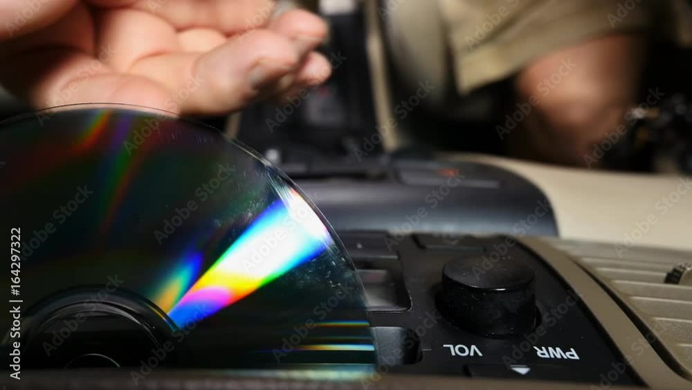 Car driver ejecting a music CD from the player