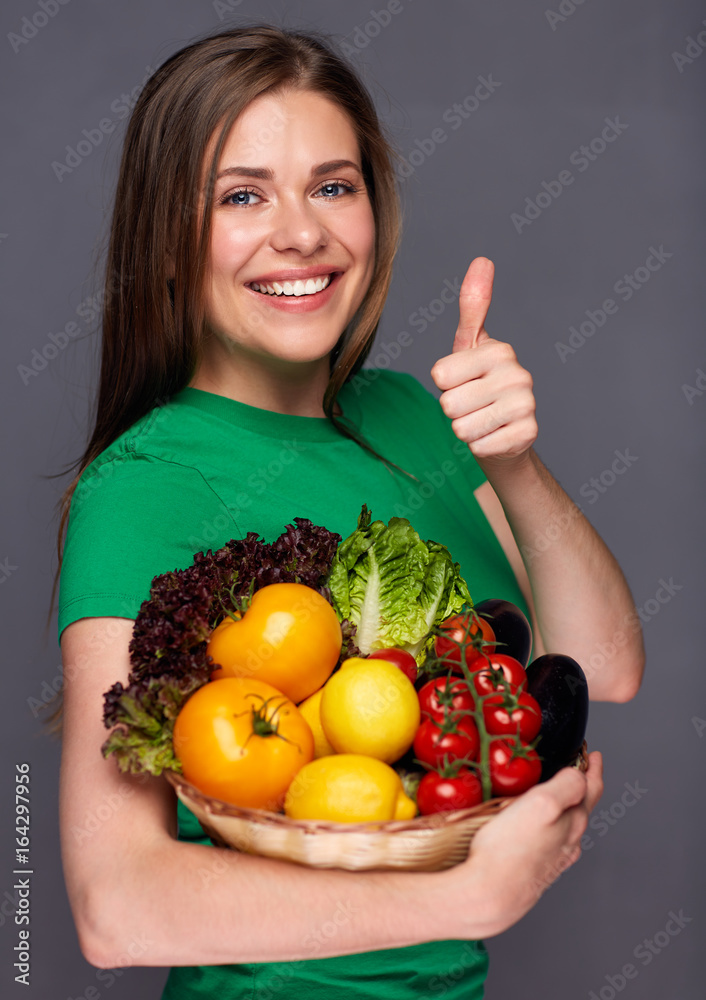 woman holding straw basket with summer vegetables giving thumb up. woman holding straw basket with summer vegetables giving thumb up.