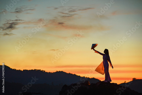 Beautiful woman with Vietnam culture traditional dress on during sunset,Vietnam