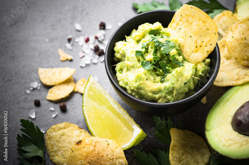 Traditional latinamerican mexican sauce guacamole and chips on b
