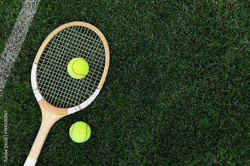 retro tennis racket on natural grass with balls. top view with copy space