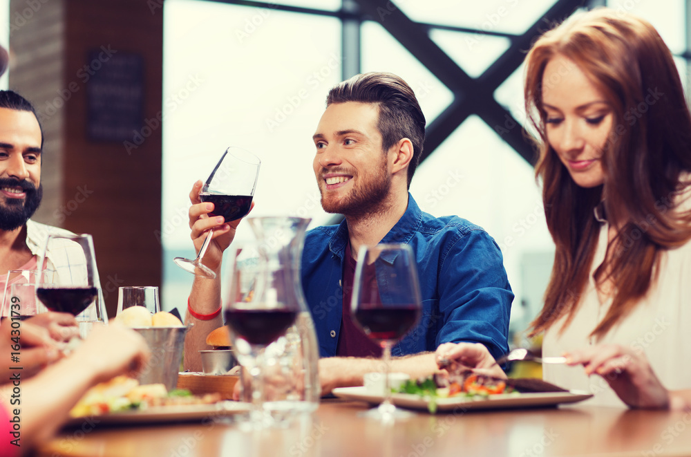 friends dining and drinking wine at restaurant