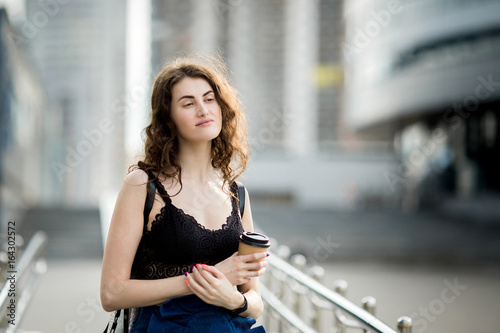 young beautiful stylish hipster woman drinking coffee in paper cup