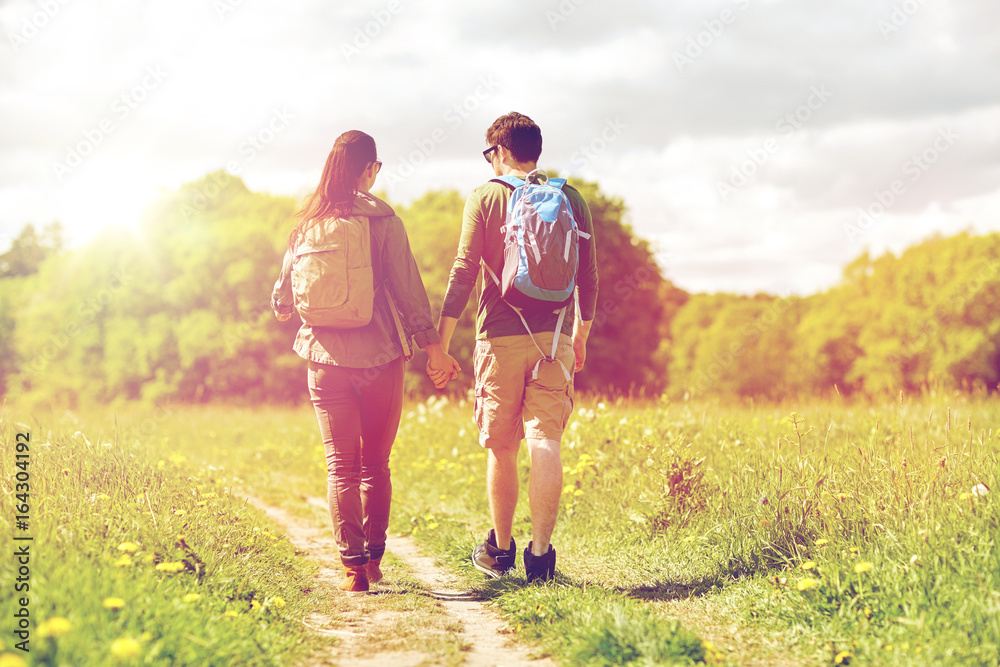happy couple with backpacks hiking outdoors happy couple with backpacks hiking outdoors