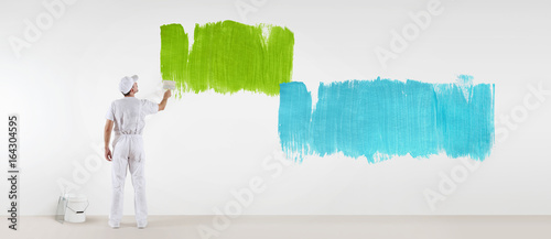 painter man with paint brush painting colors samples, isolated on blank white wall background, web banner