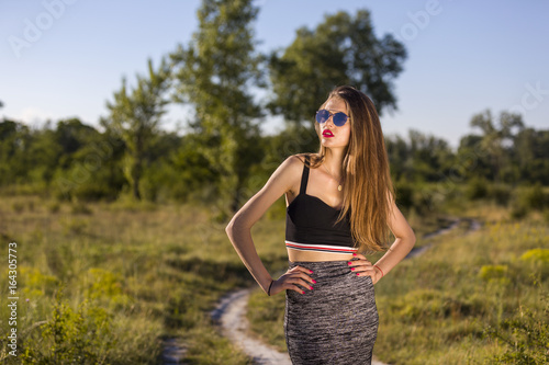 Canvas Print Young woman with sunglasses on a country lane
