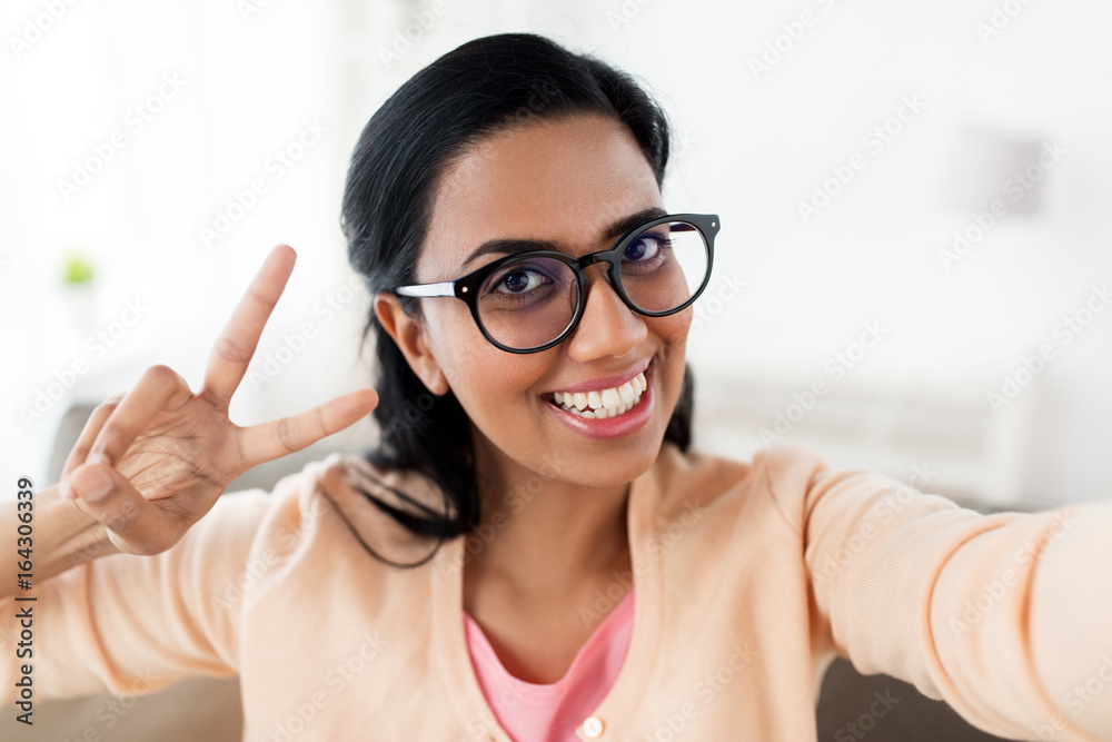 smiling woman taking selfie and showing v sign smiling woman taking selfie and showing v sign