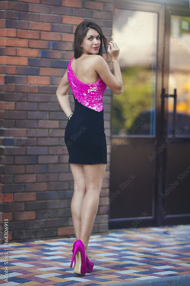 hacerte molestar Marca comercial dulce Beautiful sexy girl in short pink black dress on high heels. A young woman  with a beautiful figure and long legs walks around the city. foto de Stock  | Adobe Stock
