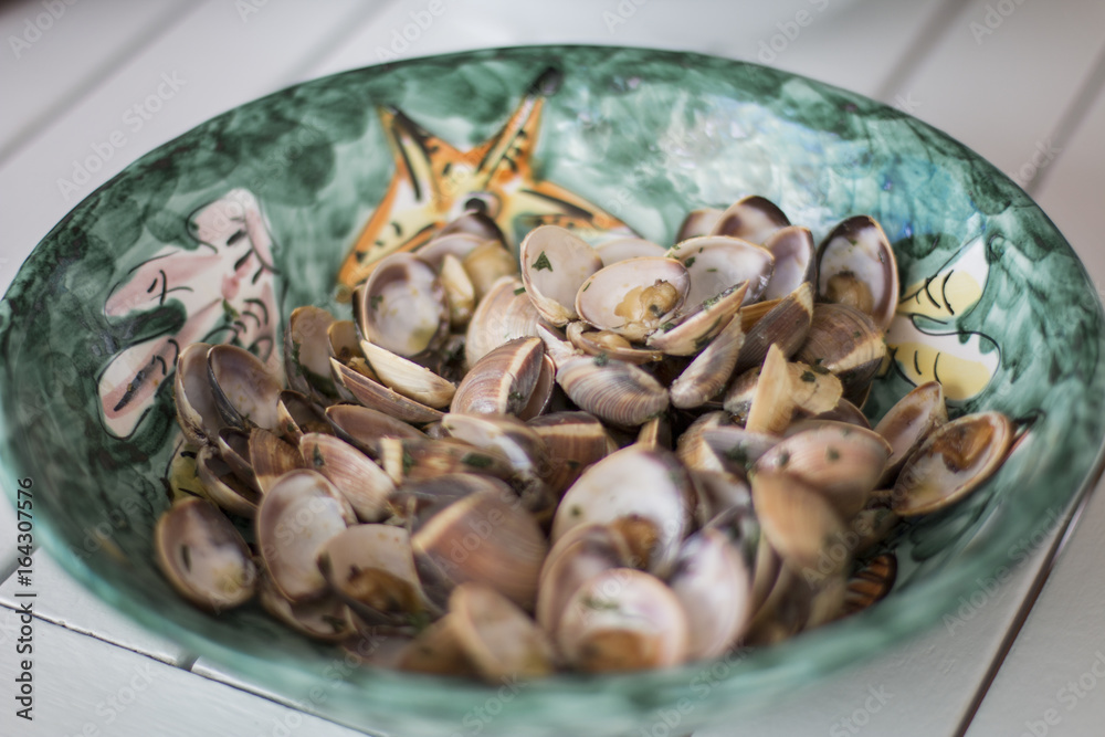Fototapeta premium A green plate with clams and parsley.