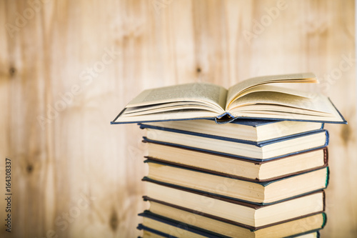 Stack of books on a wooden background.