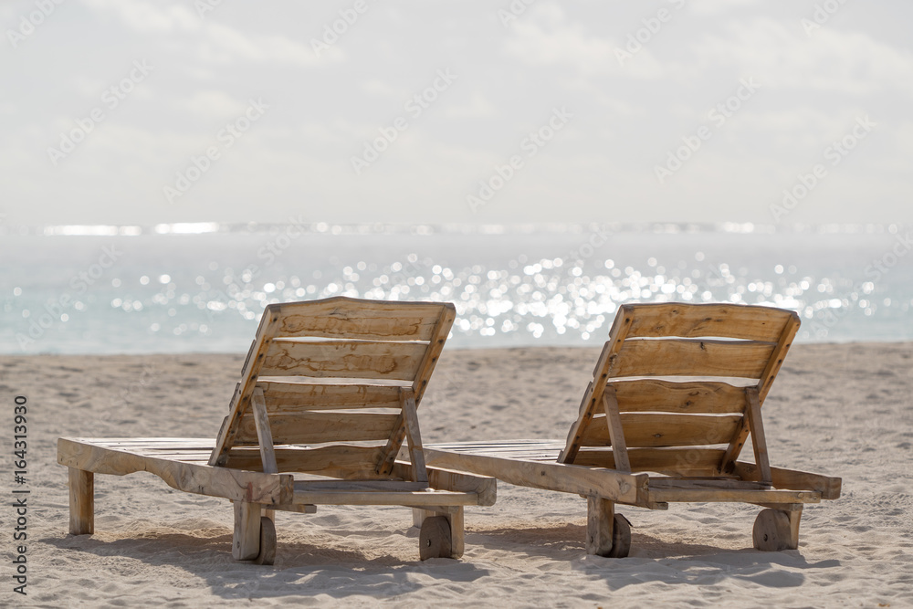Empty wooden beach chairs on the tropical beach, vacation. Traveler dreams concept Empty wooden beach chairs on the tropical beach, vacation. Traveler dreams concept